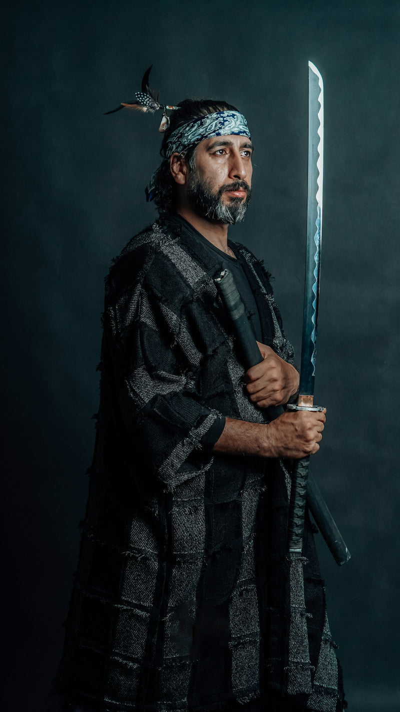 Samurai warrior in traditional Japanese attire holding a katana sword against a dark background